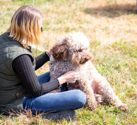 Women siting with a Lagotto Romagnolo